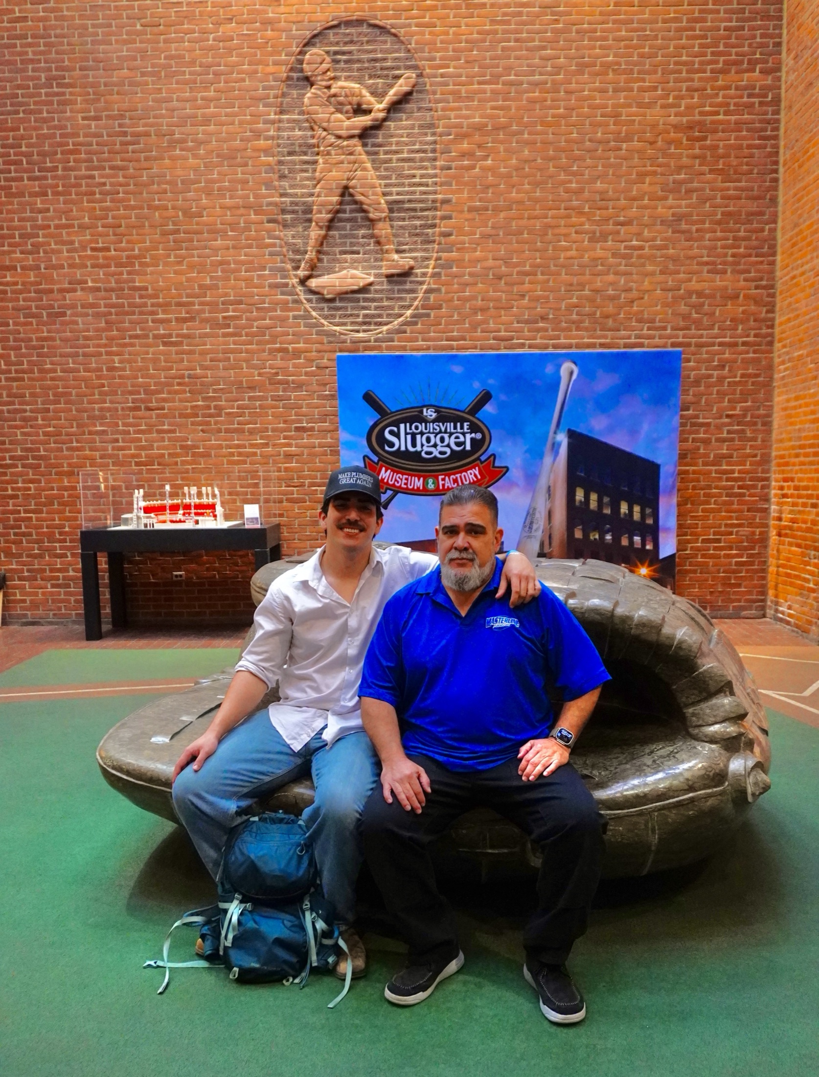 Tim Yslava sitting beside his father inside the Louisville Slugger Museum and Factory